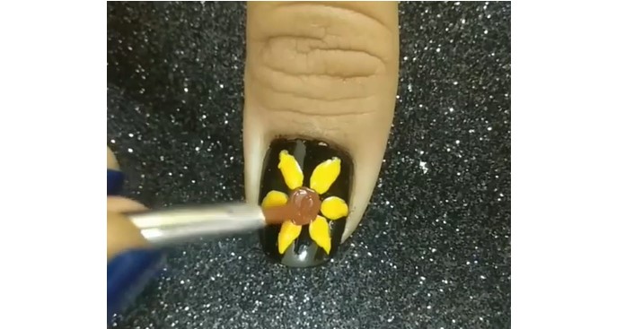 Sunflower Nail Designs: Step 3, using a thin striping brush to paint, and brown nail polish draw the center of the flowers 
