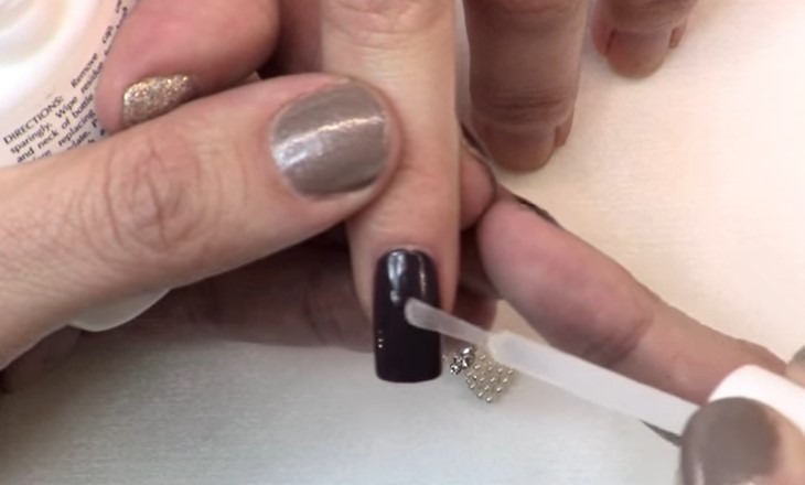 Nail Charms: Step 2, carefully apply a small dot of glue or resin to your nail 
