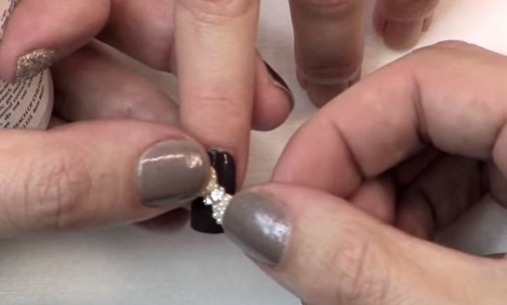 Nail Charms: Step 3, apply the nail charms on top of the glue dot and gently hold it in place 
