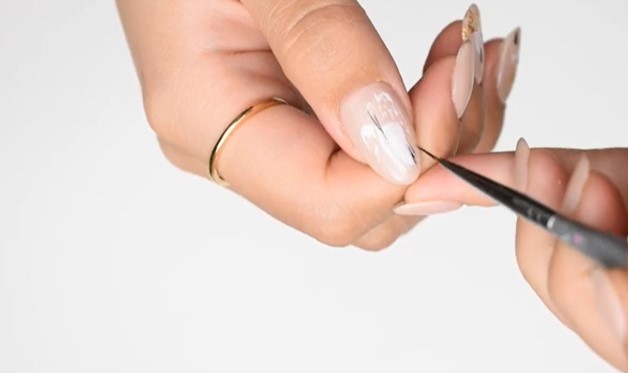 Neutral Nail Designs: Step 3, using a small detailer brush, pull the side of your dot of polish out sideways
